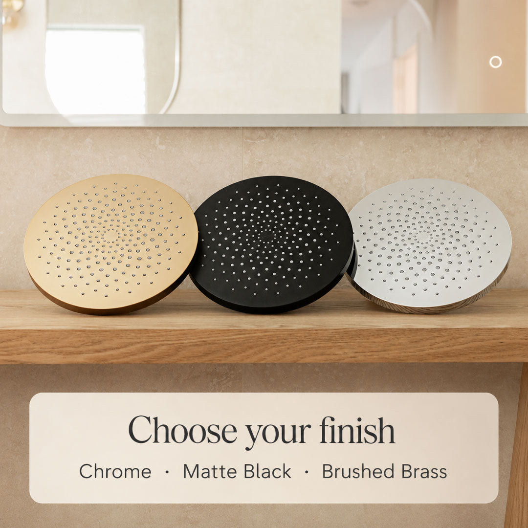 Three filtered shower heads in chrome, matte black, and brushed brass on a wooden shelf.