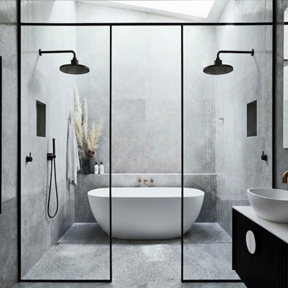 Modern bathroom with freestanding bathtub, glass shower enclosure, and black fixtures.